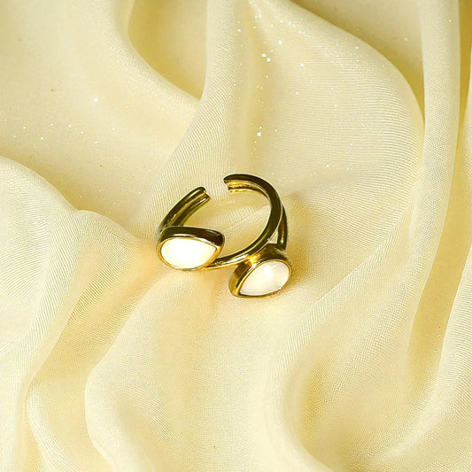 Gold-plated open ring with dual white stones on pink silk background – elegant adjustable jewelry piece for women.Gold-Plated Open Ring with White Stones