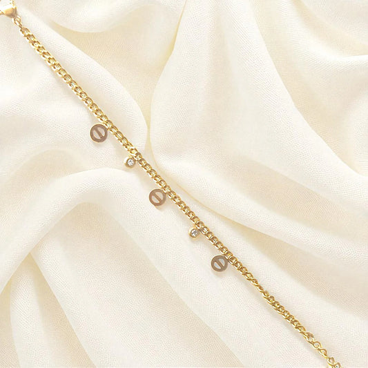 Elegant gold-plated charm bracelet with delicate round charms and cubic stones on wrist