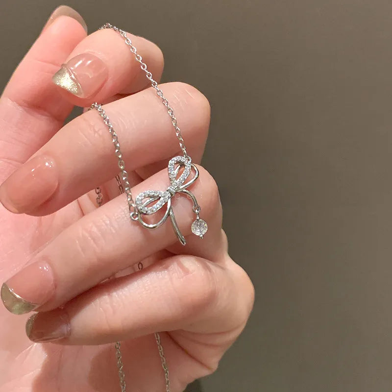 Bowknot Zircon Pendent Necklace. Elegant bowknot zircon pendant necklace in silver finish with sparkling zircon stones, dainty clavicle chain jewelry for women