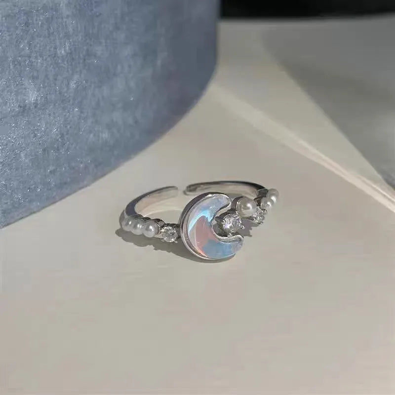 "Elegant silver adjustable pearl moon ring with opal cubic zirconia accents."