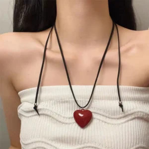Red heart pendant necklace on a black cord worn with a white top